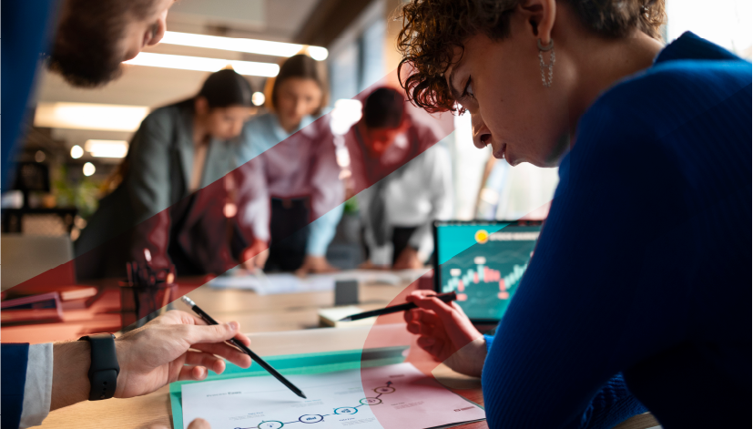 Equipe em reunião faz anotações e discute ideias em uma mesa, com pessoas ao fundo e gráficos em materiais de trabalho, em ambiente corporativo. Imagem usada para representar artigo do blog da Siteware sobre como calcular remuneração variável sem erros.
