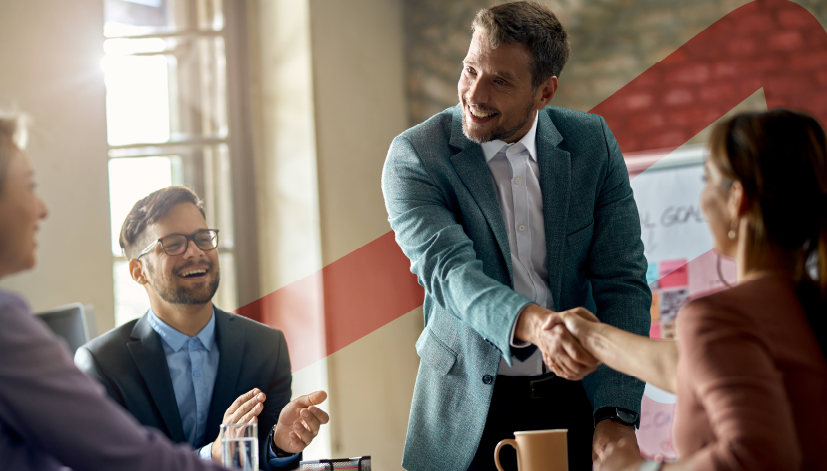 Homem de negócios sorridente cumprimenta colegas em reunião de trabalho. A imagem ilustra o artigo sobre planejamento estratégico em cooperativas, publicado no blog da Siteware.