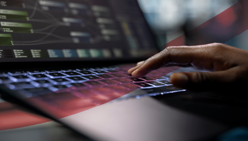 Mão digitando em notebook com dashboard de gestão empresarial exibido na tela, representando o uso de softwares de gestão para monitoramento de indicadores e processos corporativos.